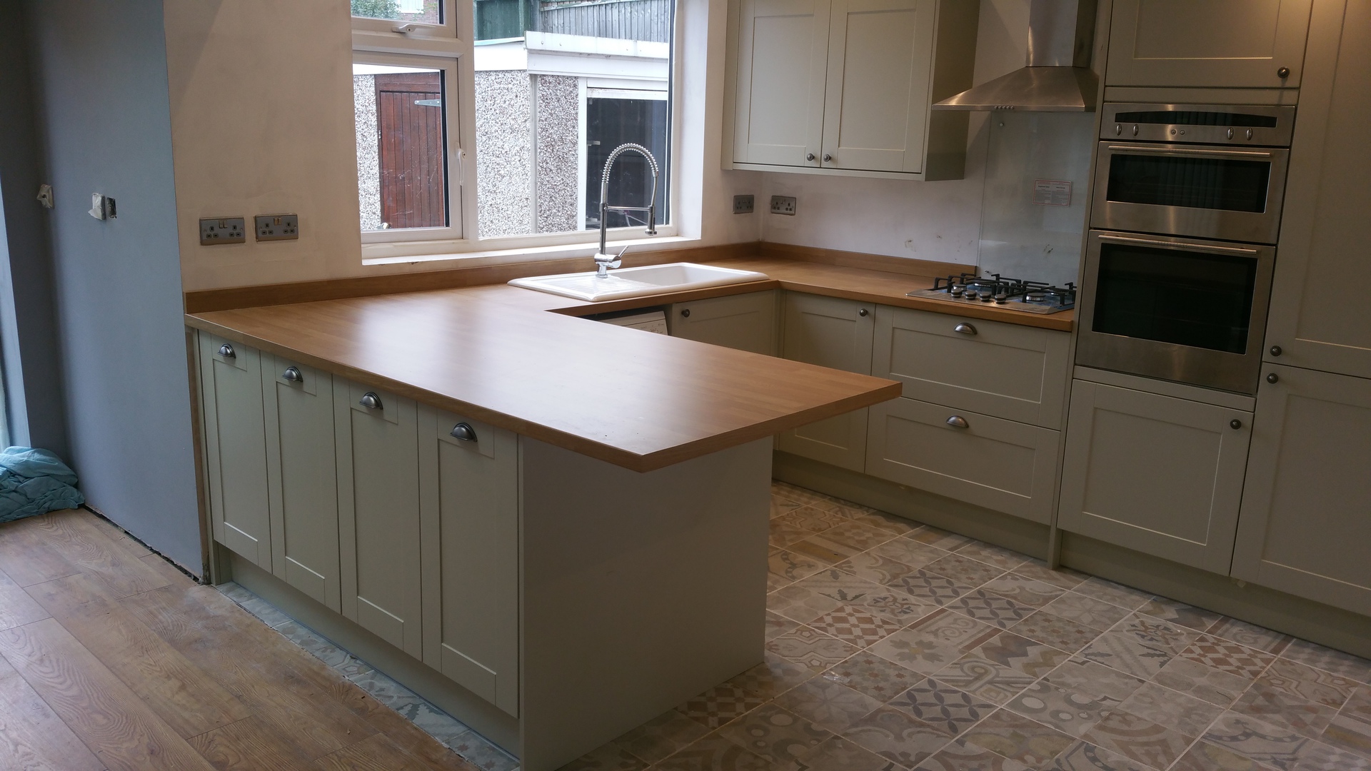 Fitted kitchen with solid oak worktops, shaker cabinets and engineered oak flooring by LMB Joinery.