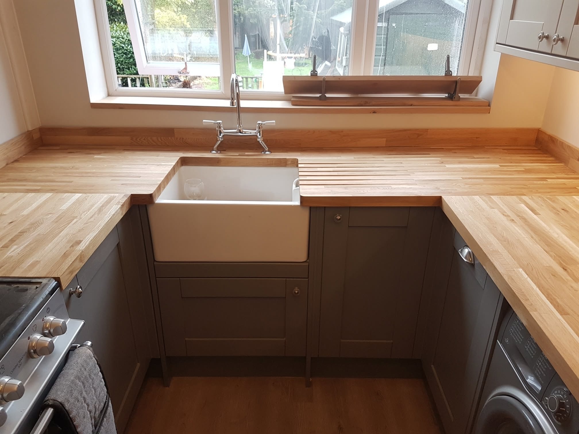 Belfast ceramic sink set into solid oak worktops with grooved drainer and bridge tap by LMB Joinery.